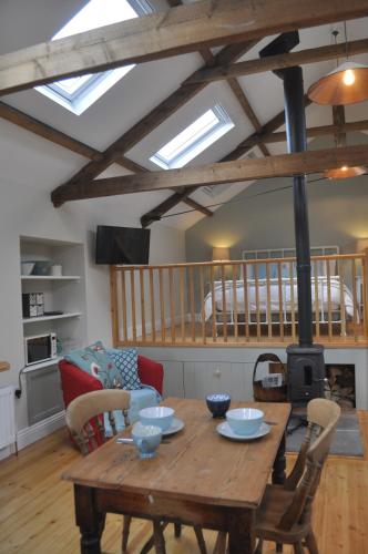 a living room with a wooden table and a wood stove at The Hay Loft Southlands Farm in Gunnerton