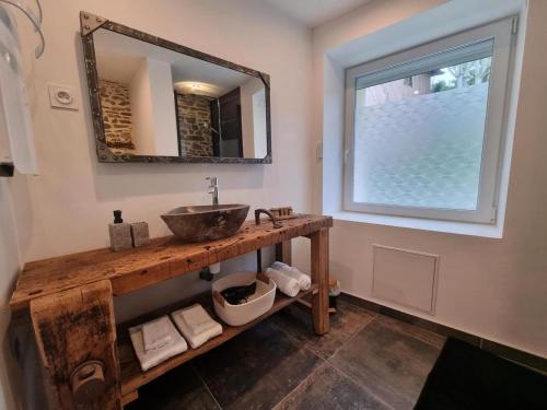 a bathroom with a sink and a mirror at La Voûte du Pilat & ces options SPA, table d'hôtes, massages in Saint-Chamond