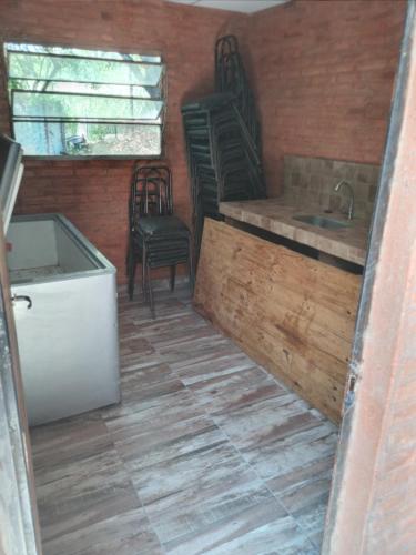 uma cozinha com cadeiras e um lavatório numa casa em Finca La Huella II em Santiago del Estero