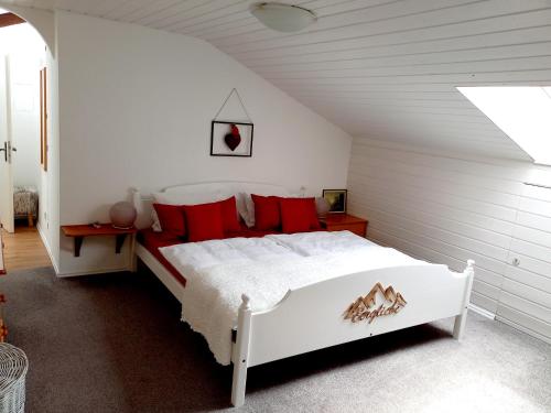 ライト・イム・ヴィンクルにあるLandhaus Bellecôteのベッドルーム(白いベッド、赤い枕付)