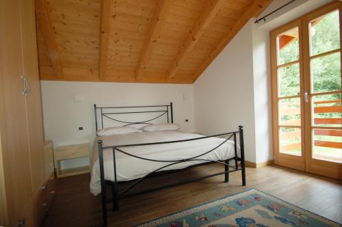 a bedroom with a bed in a room with a wooden ceiling at MASO MOLINI in Terzolas