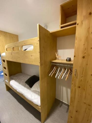 Ce lit superposé en bois se trouve dans un dortoir. dans l'établissement Le Lioran, La Sumène, Studio balcon tout confort aux pieds des pistes, à Laveissière