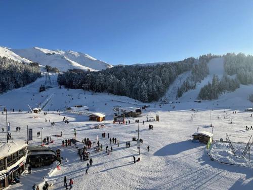 un groupe de personnes dans la neige sur une piste de ski dans l'établissement Le Lioran, La Sumène, Studio balcon tout confort aux pieds des pistes, à Laveissière