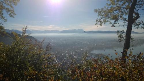 a foggy view of a city with the sun in the background at F E R I E N W O H N U N G "Am Halbenstein" in Hörbranz