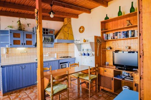 a kitchen with blue cabinets and a table with a television at Casanaga in Almáciga