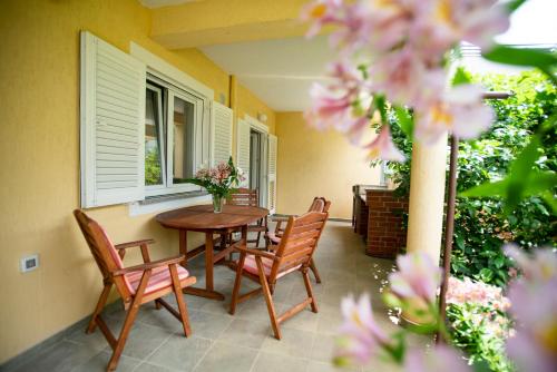 a porch with a table and chairs and flowers at Apartment Nina in Rovinj