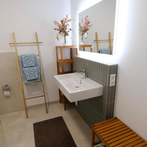a bathroom with a sink and a mirror at Neubau im Loft-Stil mit großer Terrasse in Lörrach