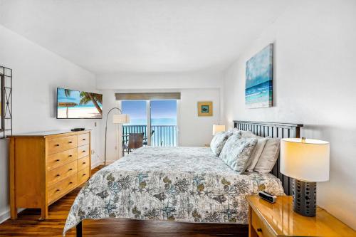 a bedroom with a bed and a dresser at Villa Madeira 505 - Premier in St. Pete Beach