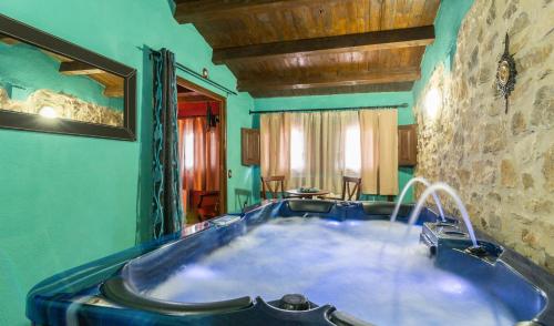 Hotel el Cantón Rural في La Cuba: حوض استحمام كبير في غرفة بجدار حجري