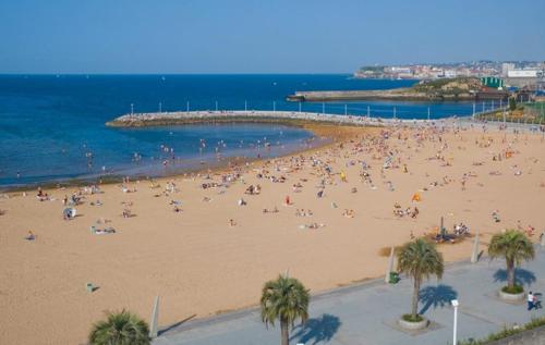 una multitud de personas en una playa cerca del océano en BRiSaS DeL NoRTe, en Gijón