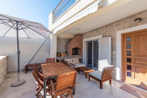 a patio with a table and chairs and an umbrella at MY DALMATIA - Holiday home near the beach Marijanka in Petrcane