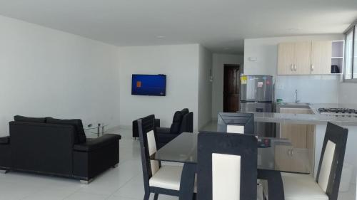 een keuken en een woonkamer met een tafel en stoelen bij Apartamento 3 Carabelas Cartagena Piso 16 in Cartagena