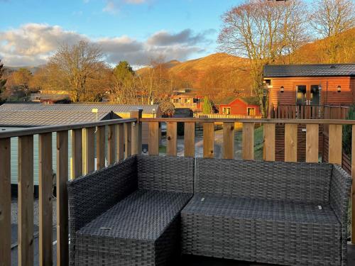 a bench sitting on a balcony with a house at Lowena Lodge in Troutbeck
