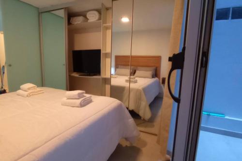 Habitación de hotel con 2 camas y espejo en Nb1 apartment free parking con cochera privada en Buenos Aires