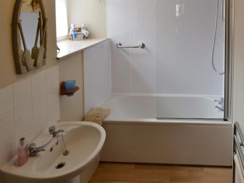 a white bathroom with a tub and a sink at Low Tide in Cellardyke