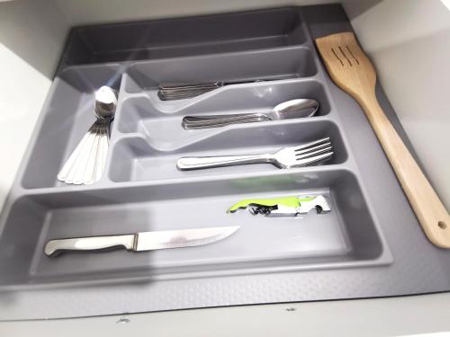 a tray with silver utensils and a knife and fork at White Studio in Câmpulung Moldovenesc