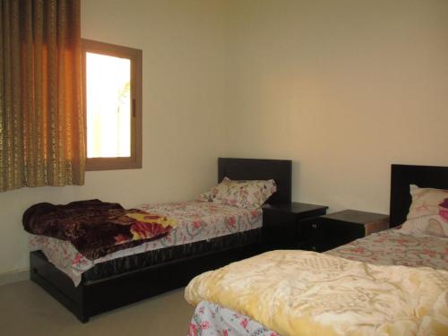 a bedroom with two beds and a window at إقامة وادي الذهب in Dakhla