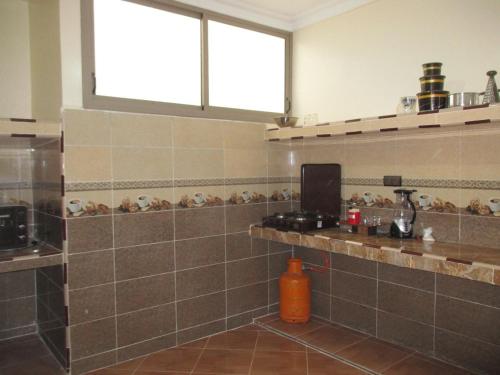 a kitchen with a tiled counter and a window at إقامة وادي الذهب in Dakhla