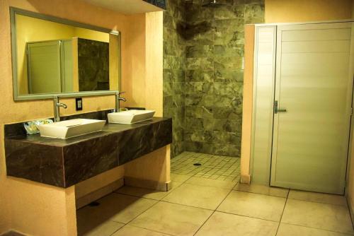 Baño con 2 lavabos y espejo en Hotel Gina, en Tecomán