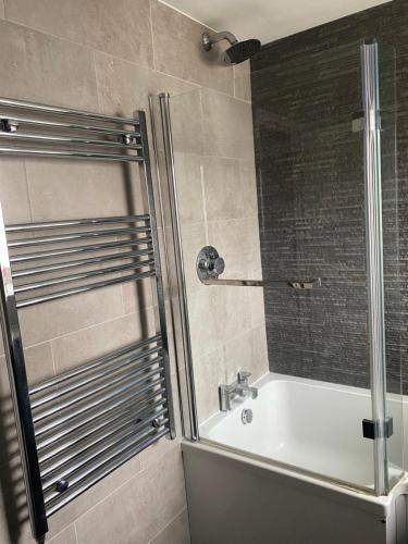 a bathroom with a shower and a tub and a sink at Foxy cottage nr Westward Ho! in Northam