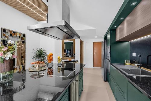 a kitchen with black counter tops and green cabinets at The Goldenhour Apartment in Makarska