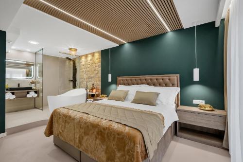 a bedroom with a large bed and a green wall at The Goldenhour Apartment in Makarska