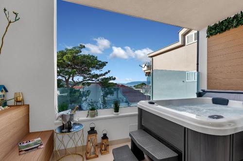 a bathroom with a tub and a large window at The Luxury Goldenhour in Makarska