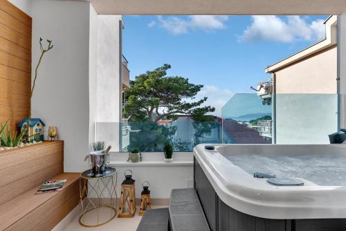 a bathroom with a tub and a large window at The Goldenhour Apartment in Makarska