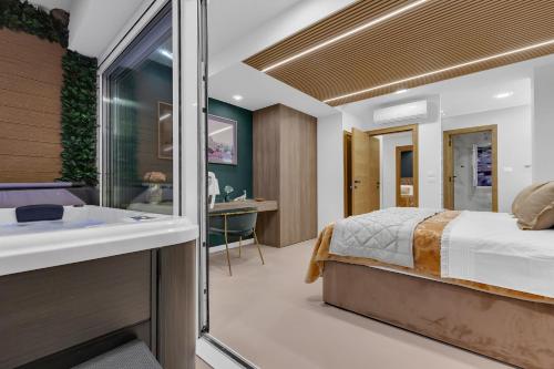 a bedroom with a bed and a bathroom with a sink at The Goldenhour Apartment in Makarska