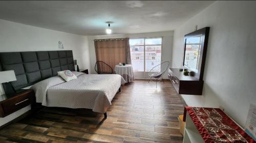 a bedroom with a bed and a table and a window at depa #5 recién remodelado en planta alta in Zacatecas