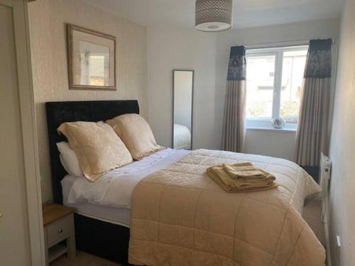 um quarto com uma cama com lençóis brancos e uma janela em Spacious 2 bedroom apartment Cleethorpes em Cleethorpes