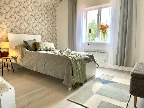 um quarto com uma cama e uma janela em Lilla Hule - på landet nära sjö em Oskarshamn