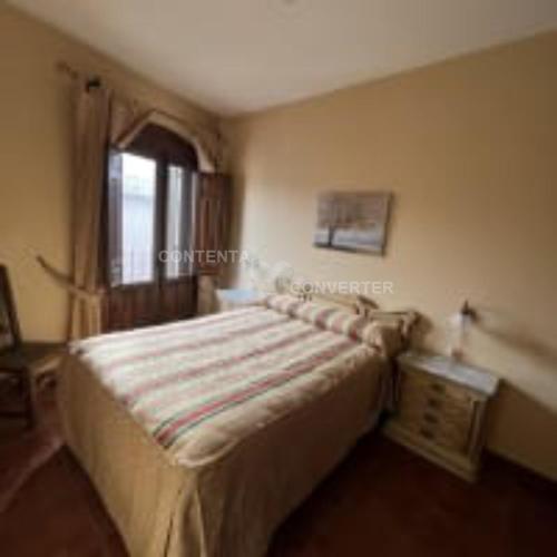 a bedroom with a bed in a room with a window at Apartamentos Turísticos La Posada in Oropesa