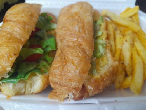 a plate of food with a sandwich and french fries at Waves Guest House in Jeffreys Bay