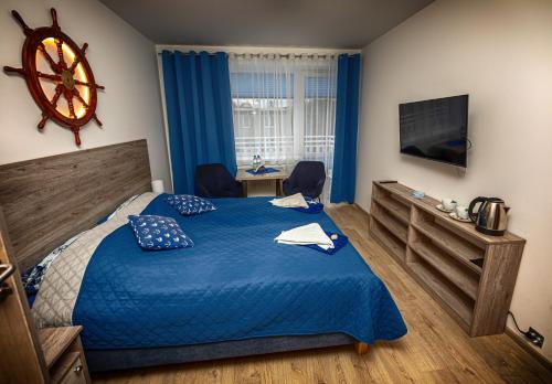 a bedroom with a bed with a blue comforter at Dom Wypoczynkowy Anna - opcjonalnie śniadania w Starej Piekarni in Kołobrzeg