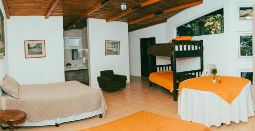 a bedroom with a bed and a bunk bed and a table at Cabañas Don Chinto in San José Pinula