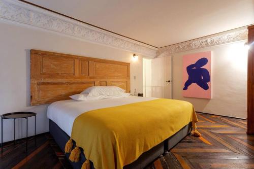 1 dormitorio con 1 cama grande con manta amarilla en Hip Loft in Historic Building, en Ciudad de México