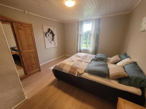 a bedroom with a large bed and a window at Skogan in Leirfjord