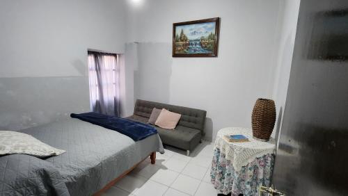 um pequeno quarto com uma cama e um sofá em Departamento céntrico y acogedor em Zacatecas