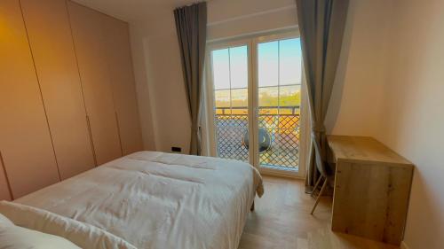 a bedroom with a bed and a window with a balcony at Floral Inn in Pristina