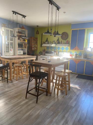 a kitchen with wooden tables and chairs in it at Auberge Internationale Le Tangon in Sept-Îles