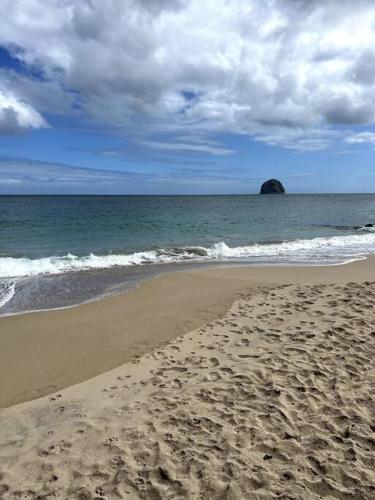 a sandy beach with a view of the ocean at The Grey Rocks Studio in Le Diamant