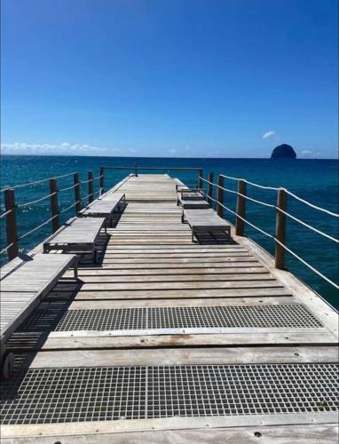 a dock in the middle of the ocean at The Grey Rocks Studio in Le Diamant