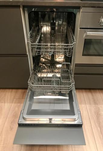 an open dishwasher with its door open in a kitchen at Central penthouse with spectacular sea and city views in Genova