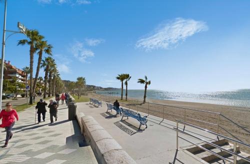 people walking on a sidewalk next to the beach at BYPILLOW Villa Lorena Adults Recommended in Málaga