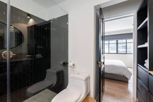 een badkamer met een toilet en een douche en een bed bij Chic Luxury Apartment in Polanco in Mexico-Stad