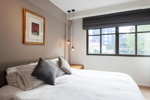 1 cama blanca en un dormitorio con ventana en Chic Luxury Apartment in Polanco, en Ciudad de México