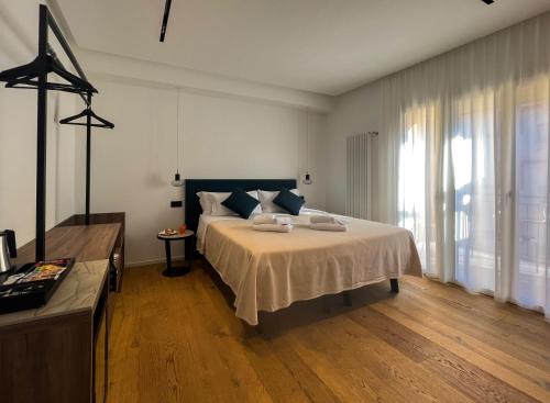 B&B Le Suites di Costanza في تشفالو: غرفة نوم بسرير كبير ونافذة كبيرة
