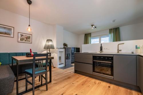 a kitchen and living room with a table and a couch at Berg Apartment-Berg im Drautal in Berg im Drautal