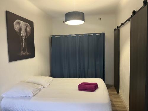 une chambre avec un lit avec une serviette rouge dessus dans l'établissement L'Eden - Joli studio en centre ville, à Nîmes